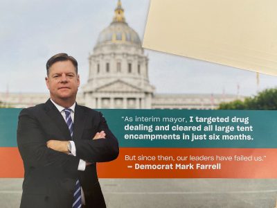 A man in a suit stands with arms crossed in front of a domed building. The text reads: "As interim mayor, I targeted drug dealing and cleared all large tent encampments in just six months. –Democrat Mark Farrell.