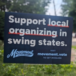 A yard sign reads: "Support local organizing in swing states. Visit movement.vote to get involved.