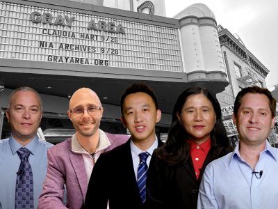 A group of five people standing in front of a marquee sign that reads "GRAY AREA" followed by event details, with a building in the background.