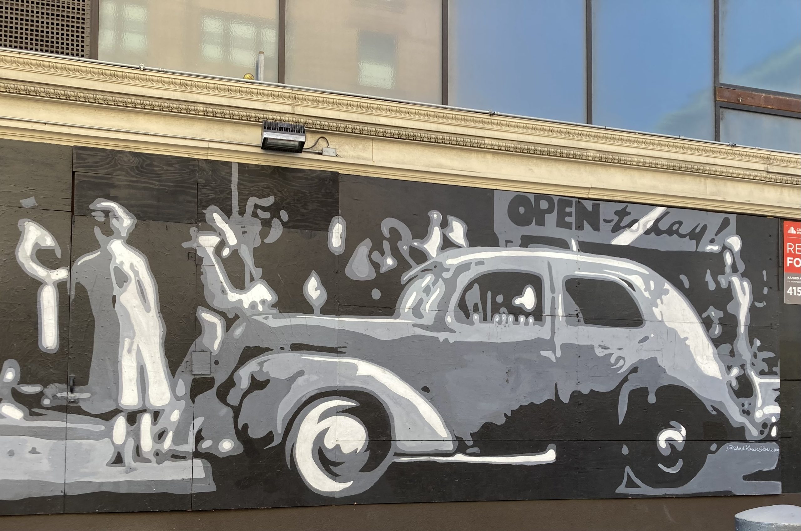A grayscale mural of a vintage car and a person in a coat and hat, with the words "Open today" above them.