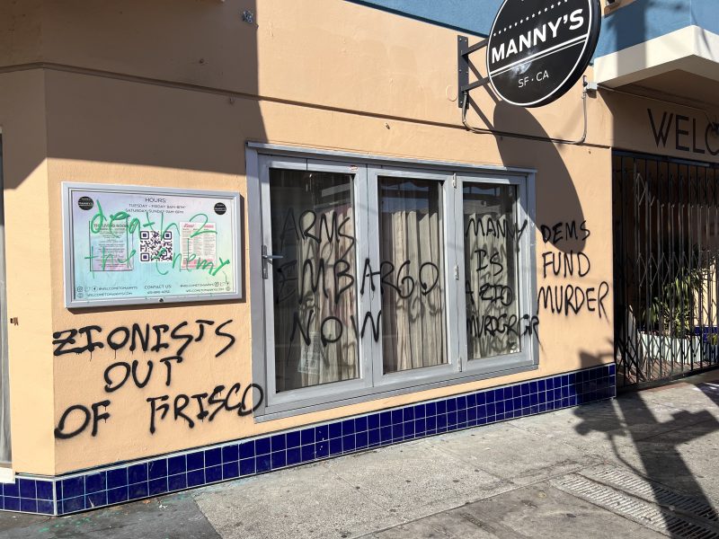 Building with graffiti on its walls, including phrases like "Zionists out of Frisco," "Arms embargo now," and "Dems fund murder."