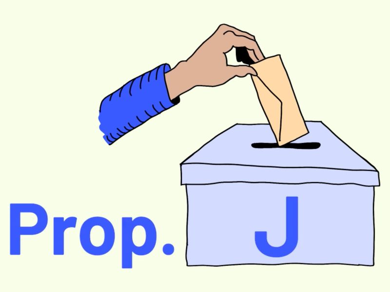 A hand places a ballot into a box labeled "Prop. J".