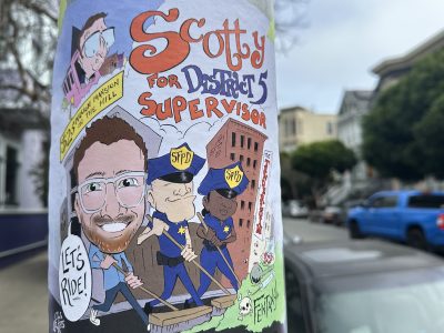 A colorful street poster features a cartoon character named Scotty Jacobs campaigning for District 5 Supervisor, surrounded by cartoon police officers and city buildings, with the phrase "Let's Ride!
