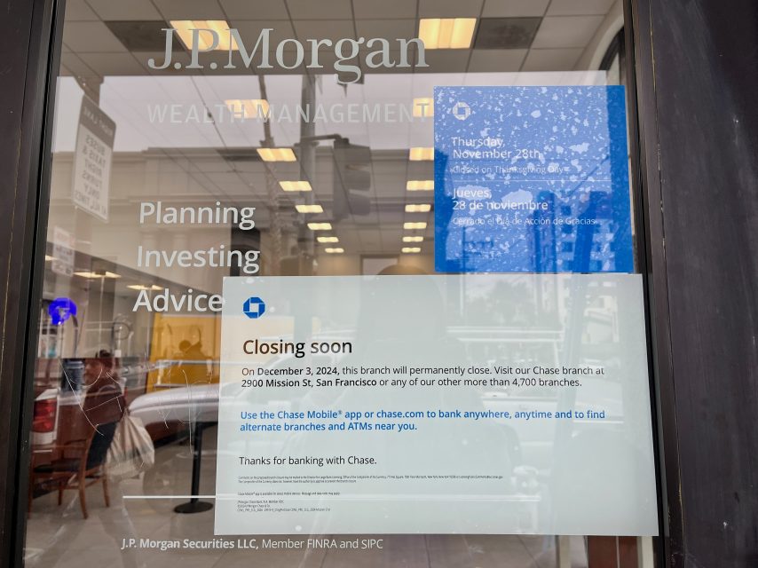 Sign on J.P. Morgan branch door stating closure of the San Francisco location on December 9, 2024, with information on continued services via Chase Mobile app and other branches.