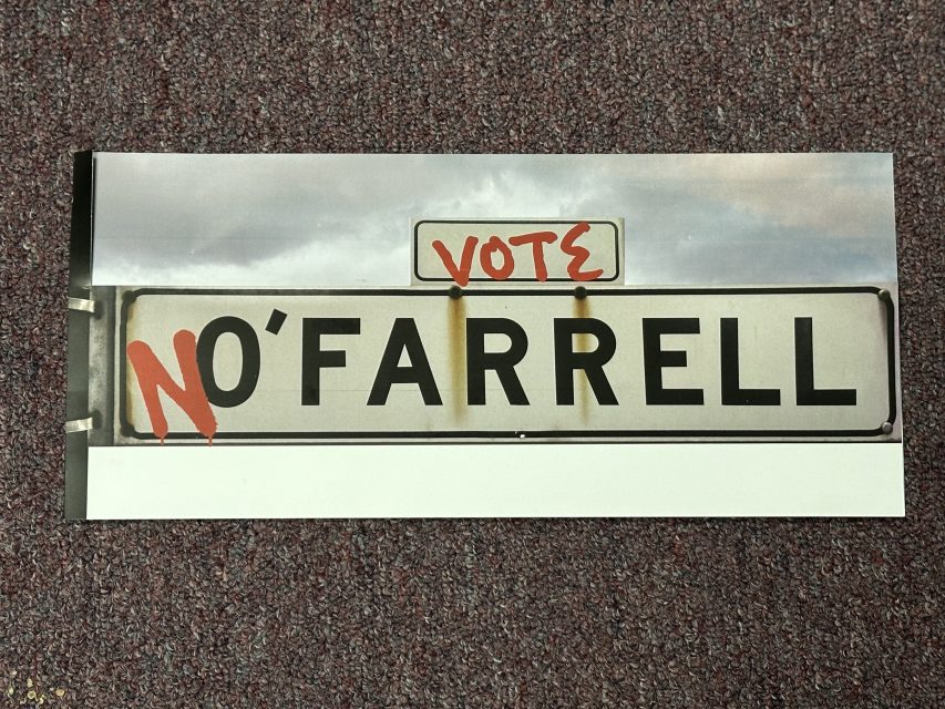 A sign with the text "O'FARRELL" is defaced with spray paint reading "NO" before and "VOTE" above it, echoing the tension of an SF election.