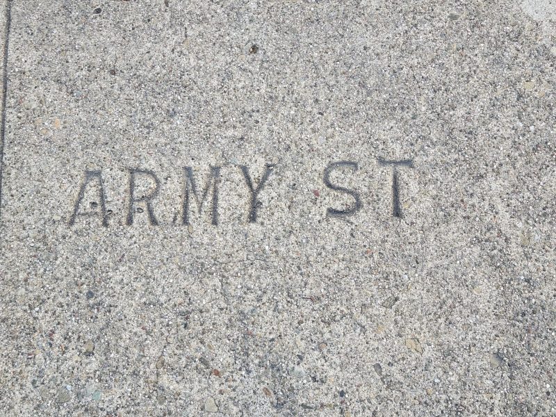 Concrete sidewalk with the words "ARMY ST" embossed on the surface.