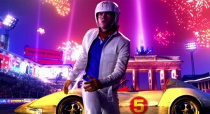 A person in a white racing suit and helmet stands in front of a golden race car numbered 5, with colorful fireworks in the background.