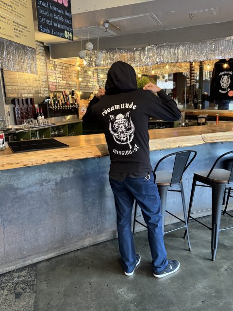 Danny Mendez, co-owner of Rosamunde, posing with the business' merch on Thursday Jan. 30, 2025. Photo by Oscar Palma.