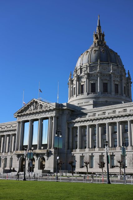 A historic building with a large dome and neoclassical facade under a clear blue sky.