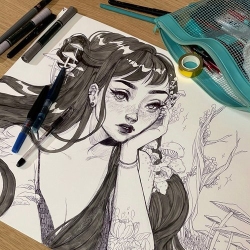 Illustration of a long-haired girl surrounded by art supplies, including pens, pencils, and a mesh pouch, on a wooden table.