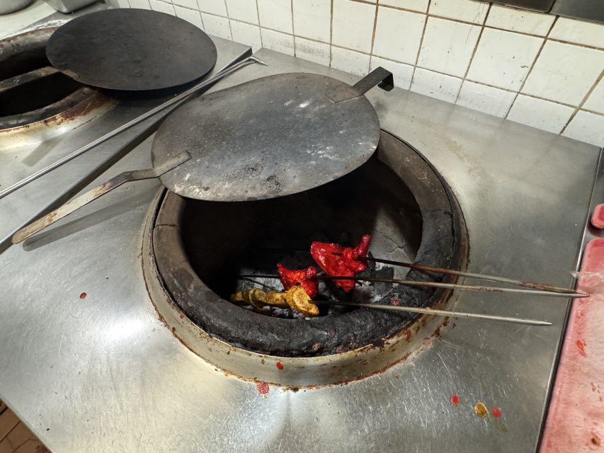 Tandoori chicken and fish cooking inside at tandoori oven on Monday Feb. 24, 2025. Photo by Oscar Palma.