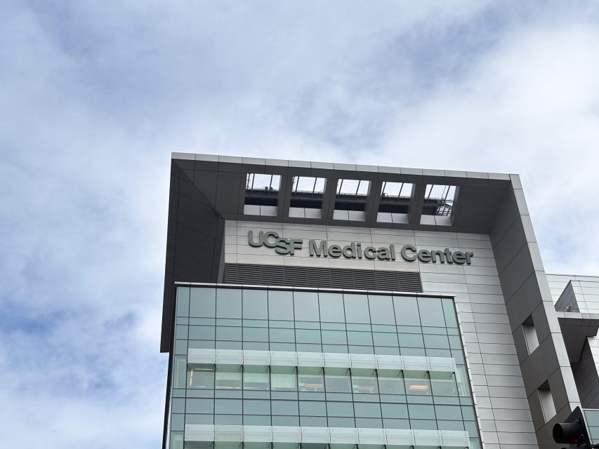 Exterior view of UCSF Medical Center building with a modern design and large glass windows, set against a cloudy sky.