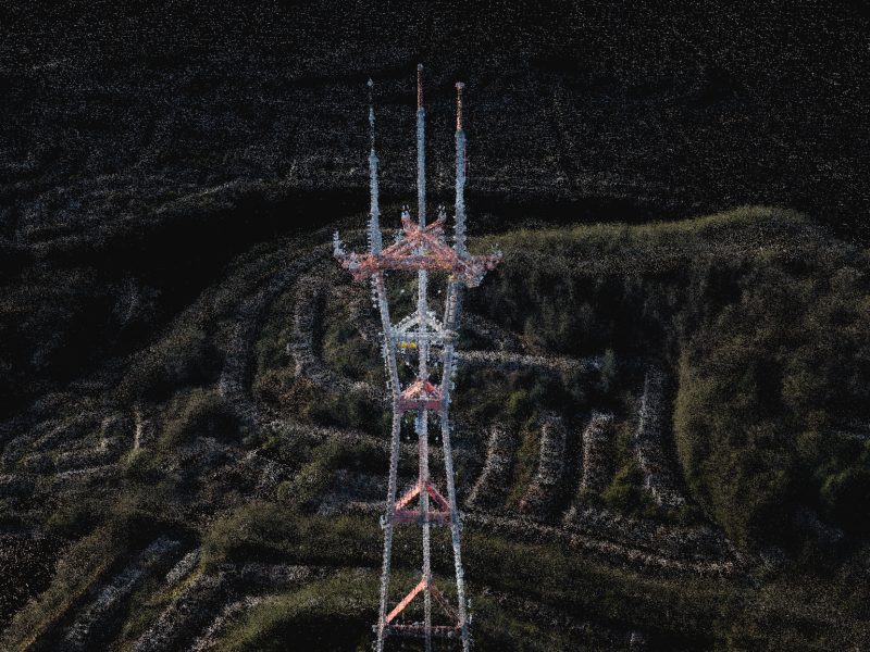 Amidst a dark landscape, the towering Sutro radio antenna rises majestically, its red and white stripes slicing through the sky, surrounded by lush greenery and winding trails.