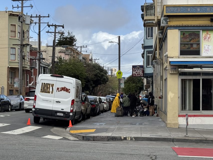 A street scene shows a van labeled "Ariel's Plumbing" parked near a group of people on a city corner, next to a building with a sign that reads "Maliase Hotel.