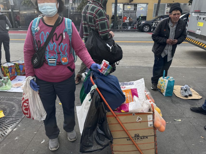 A woman sells groceries and cigarettes at the bus stop next to the Northeastern 16th Street BART plaza on Monday March 1o, 2025. Photo by Oscar Palma.