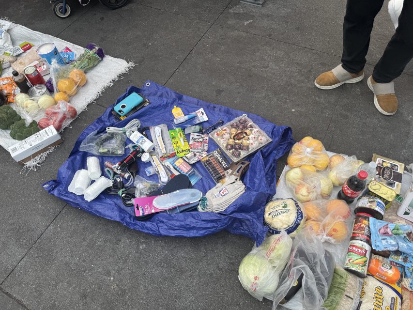 A group sells a variety of goods at the bus stop next to the Northeastern 16th Street BART plaza on Monday March 1o, 2025. Photo by Oscar Palma.