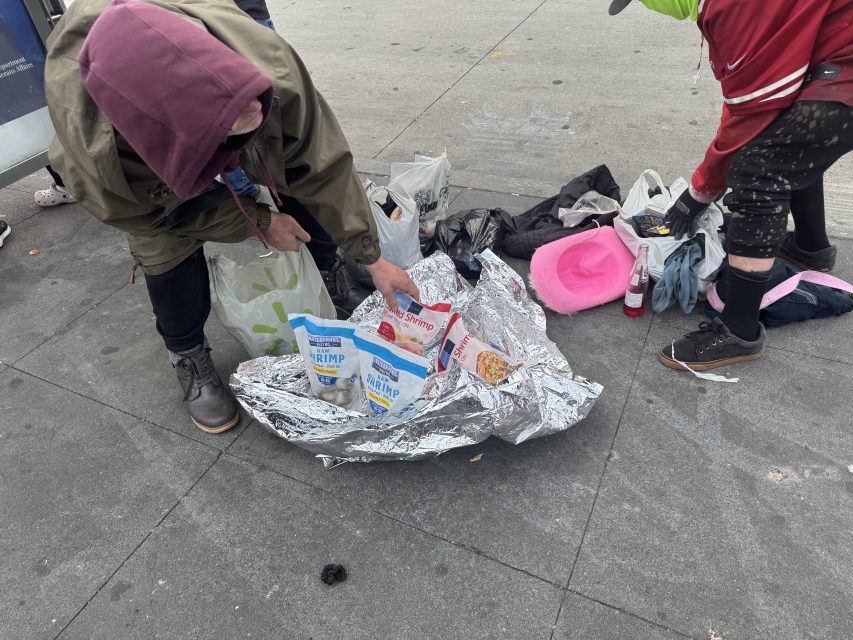 Two men arrive with melting bags of frozen shrimp, which they sell for $10 apiece on Monday March 10, 2025. Photo by Oscar Palma.
