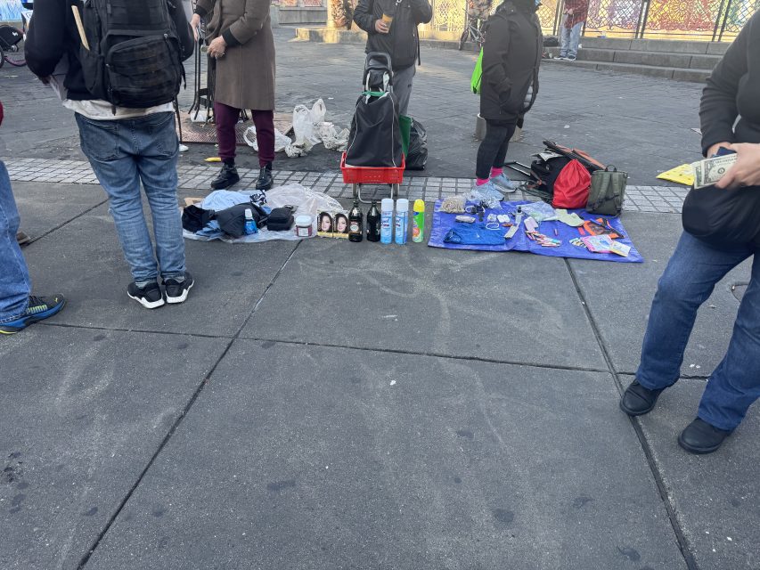 A vendor offering cleaning and beauty supplies and olive oil outside of the Southwestern 16th Street BART plaza on Tuesday March 11, 2025. Photo by Oscar Palma.