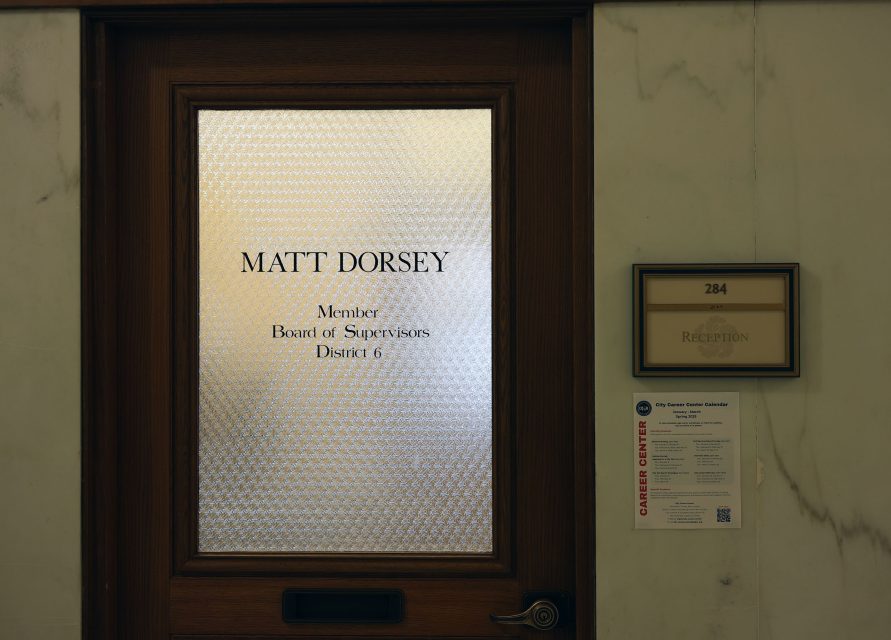 Wooden door with frosted glass labeled "Matt Dorsey, Member, Board of Supervisors, District 6." Adjacent signs include "284 Reception" and a Career Center flyer.