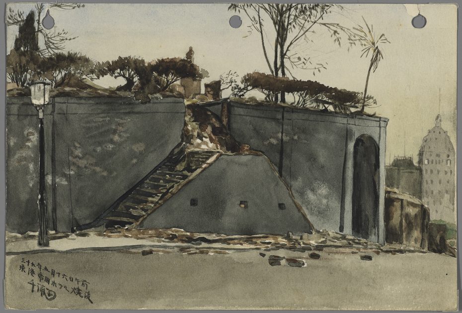 A stone staircase leads up to a terrace with sparse trees and shrubs, bordered by high stone walls; a lamp post stands on the left and a tall building is visible in the background.