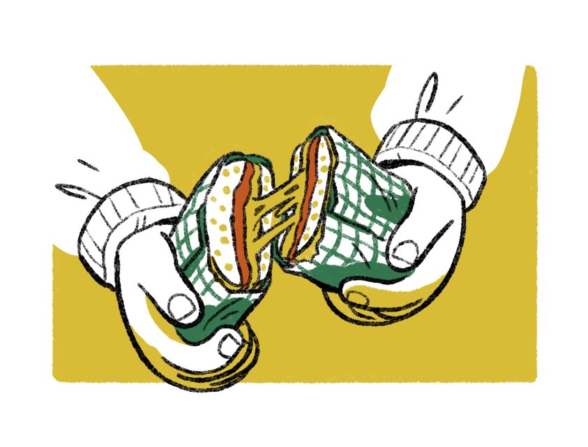 Two hands pull apart a wrapped sandwich with melted cheese stretching between the halves, set against a yellow background.