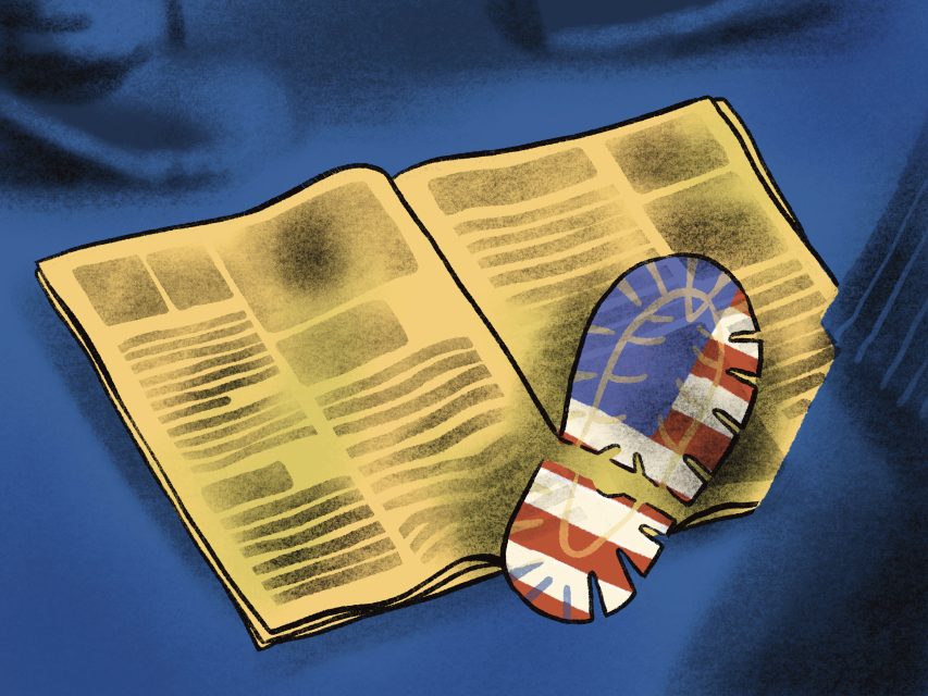An open newspaper lies on a blue surface with a large shoe print featuring the British flag pattern stamped across its pages.