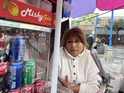 Solinda Parraga standing next to her fruit cart at the northeastern 16th BART plaza on Monday March 31, 2025. Photo by Oscar Palma.
