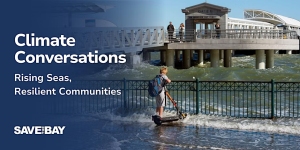 A person rides a scooter through a flooded walkway near a waterfront, with waves splashing against a metal fence and people standing on a pier in the background. Text reads "Climate Conversations.