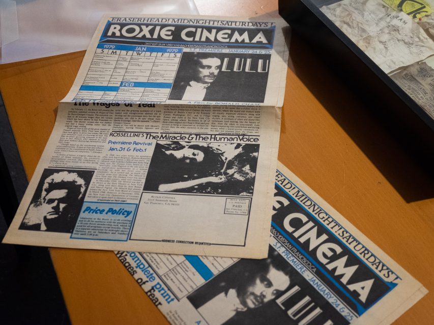 Two vintage Roxie Cinema newsletters lie open on a wooden surface, displaying black-and-white movie ads and schedules for January and February film screenings.