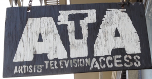 A weathered wooden sign reads "ATA Artists' Television Access" in bold, white, distressed lettering.