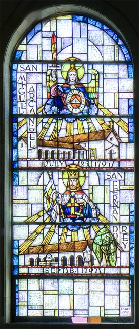 Stained glass window depicting Saint Michael the Archangel above a church, and a bishop below with mission buildings and a date: September 8, 1797.