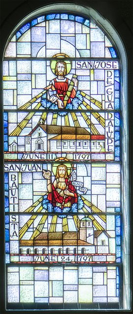Stained glass window depicting religious figures, labeled San Jose de Guadalupe and San Juan Bautista, with churches and dates June 11, 1797 and June 24, 1797.