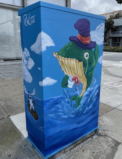 A painted utility box featuring a green whale in a purple hat emerging from the ocean, holding a red-and-white striped object, with a small boat and figure on the side.