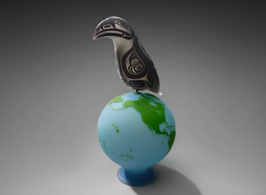 A stylized black and silver bird sculpture with Indigenous art motifs is perched on top of a blue and green globe against a grey background.