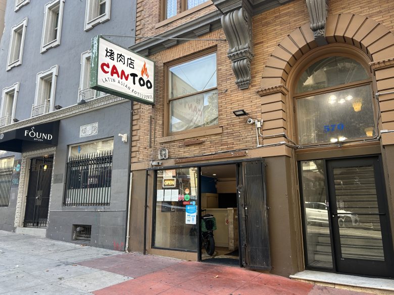 Street view of CanToo, a restaurant with a sign reading "Latin, Asian, Rotisserie" and an open door. Neighboring businesses and building facades are also visible.