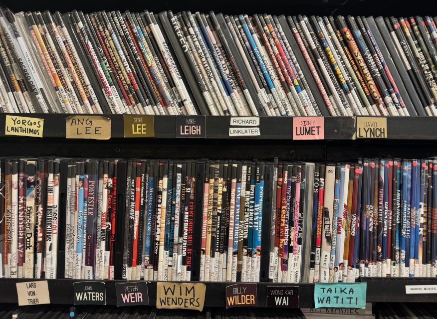 A shelf of DVDs organized by director, with handwritten labels for each director's name visible on the shelves.