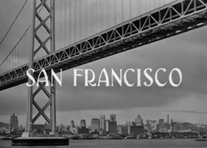 Black and white image of the San Francisco skyline seen beneath a large bridge with the words "San Francisco" overlaid in bold letters.