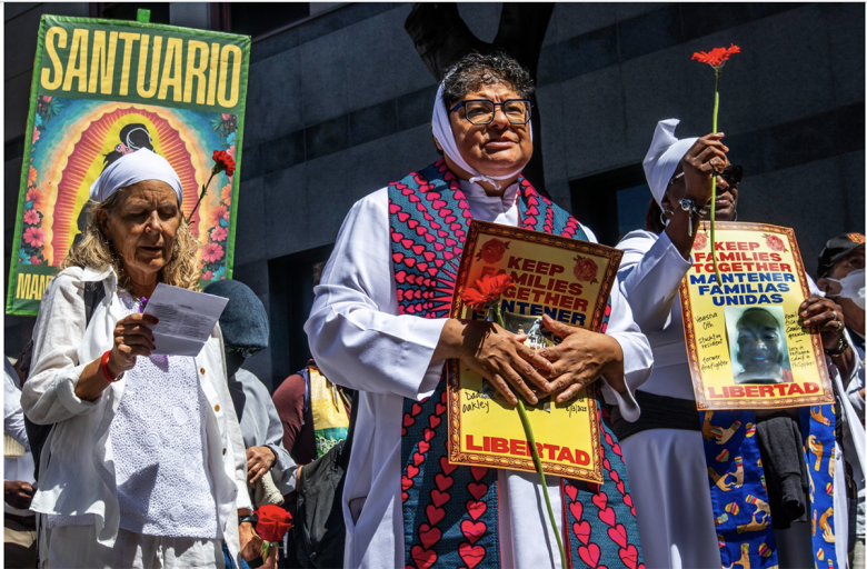 A group of women at a protest hold signs reading "Keep Families Together" and "Libertad," with one holding a red carnation. A "Santuario" banner is visible in the background.