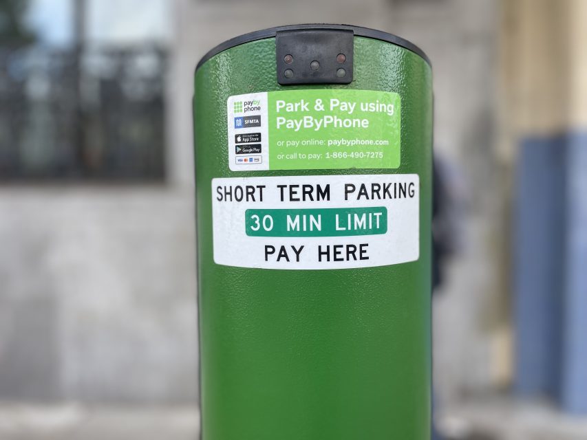 Green parking meter with signs stating "Short Term Parking 30 Min Limit Pay Here" and instructions to pay using the PayByPhone app or phone number.