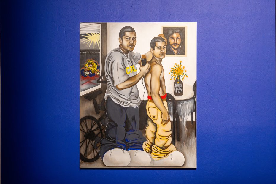 A painting of two men, one dressed and one shirtless, standing indoors with household items and a framed portrait on a vivid blue wall.
