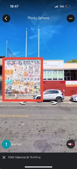 A silver SUV parked on the street in front of a building with a colorful mural and a sign reading "Mission Federal Credit Union" under a clear blue sky.