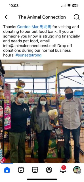 Three people wearing masks stand in a pet supply store next to shelves of pet food. A message above thanks a visitor for supporting the pet food bank and provides donation instructions.
