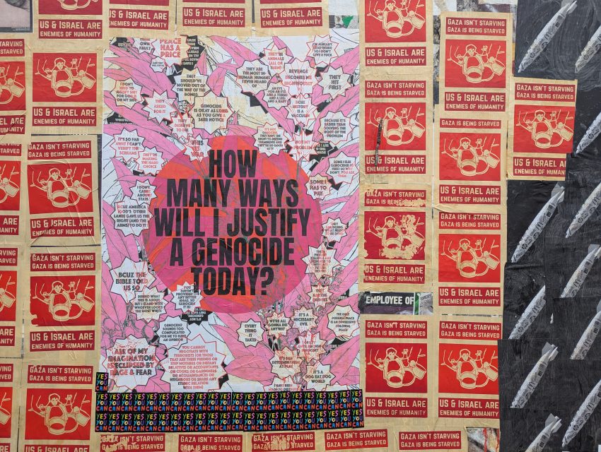 A wall covered in posters, with a large central sign reading "How many ways will I justify a genocide today?" surrounded by red and black protest flyers about Gaza and U.S.–Israel.