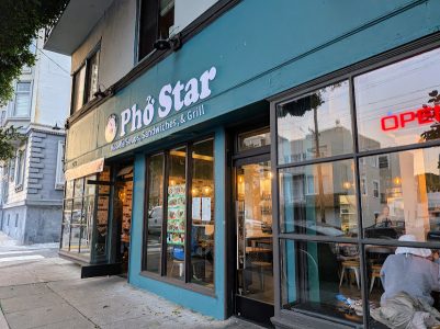 Storefront of Pho Star restaurant with a teal exterior, large windows, and a sign advertising noodle soups, sandwiches, and grill; an "OPEN" sign is visible in the window.