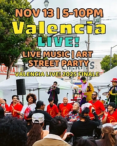 Outdoor street event with musicians and performers on stage, colorful signage promoting Valencia Live! with live music, art, and a crowd of attendees.