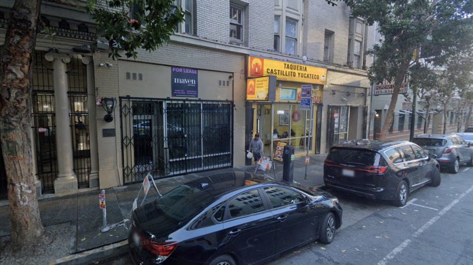 Street view of a taqueria with a bright yellow sign, neighboring buildings, parked cars, and a "For Lease" sign visible on the left side.