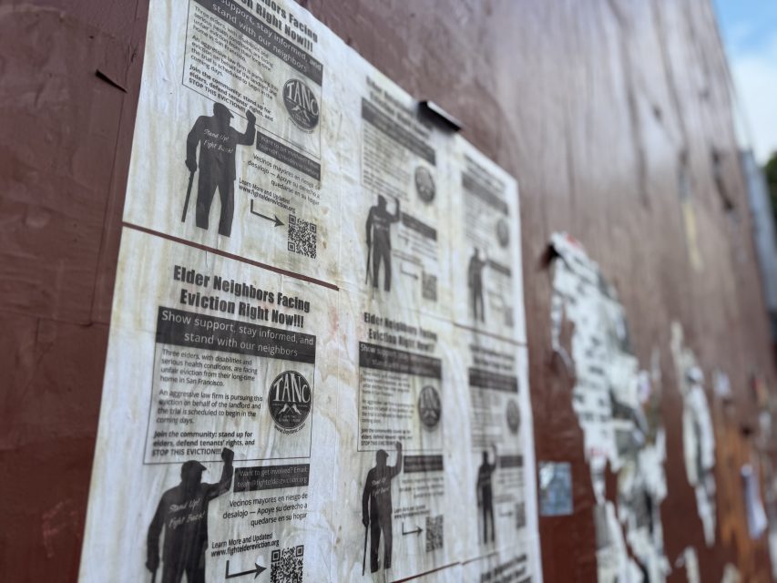 A close-up of weathered flyers on a wall, with bold text about elder neighbor evictions and a TANC logo, calling for community action and support.