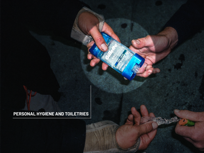 Two people exchange a bottle of Gillette clear gel antiperspirant. One person holds a string or rope, and the background is a dark surface. Text reads: "Personal Hygiene and Toiletries.