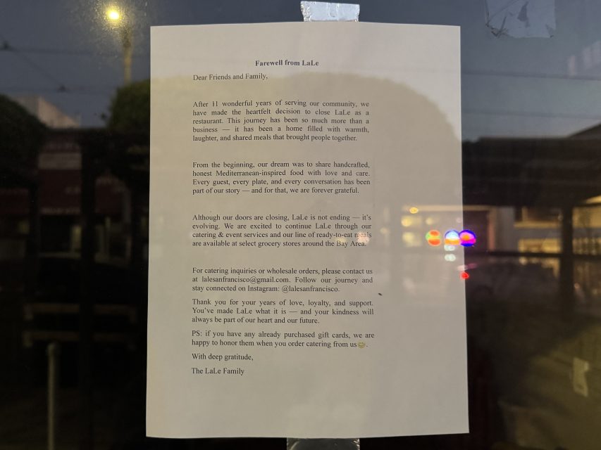 A printed farewell letter from Lale is taped to a glass window, announcing the cafe’s closure and expressing gratitude to customers and the community.