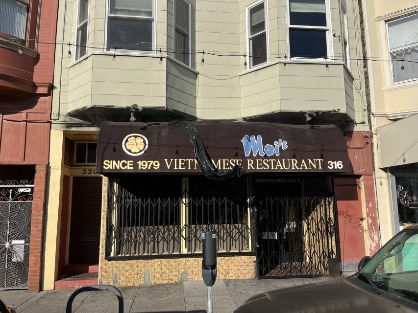 A closed Vietnamese restaurant with a brown awning reading "Moi's Vietnamese Restaurant Since 1979" and address number 316, with metal security gates over the windows and door.